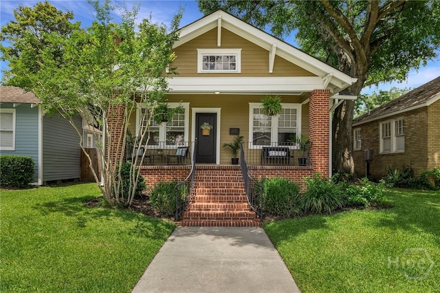 316 E 51st St, Savannah, GA 31405 - view of front of property with a front yard, covered porch, and brick siding
