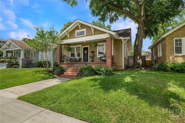 316 E 51st St, Savannah, GA 31405 - bungalow-style home with a front yard, a porch, stairs, and brick siding