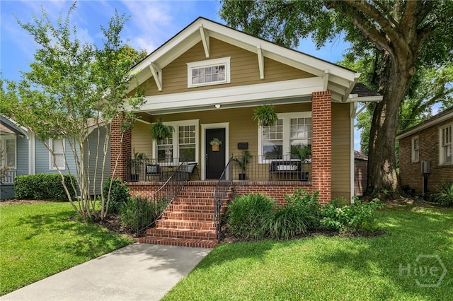 316 E 51st St, Savannah, GA 31405 - view of front of property with a front yard, brick siding, and covered porch