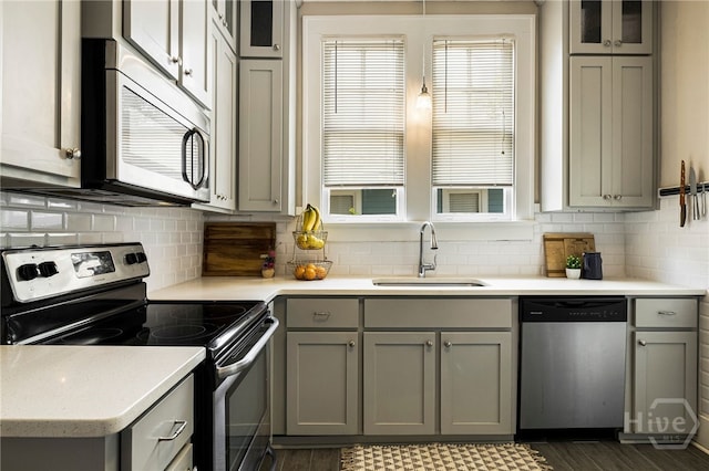 316 E 51st St, Savannah, GA 31405 - kitchen with stainless steel appliances, gray cabinets, tasteful backsplash, light countertops, and glass insert cabinets