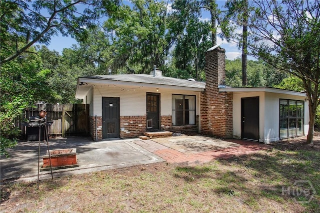 5527 Habersham St, Savannah, GA 31405 - view of front facade featuring a chimney, brick siding, and a patio area