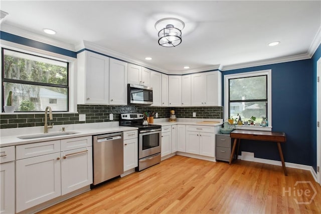 5527 Habersham St, Savannah, GA 31405 - kitchen featuring appliances with stainless steel finishes, crown molding, light countertops, backsplash, and plenty of natural light
