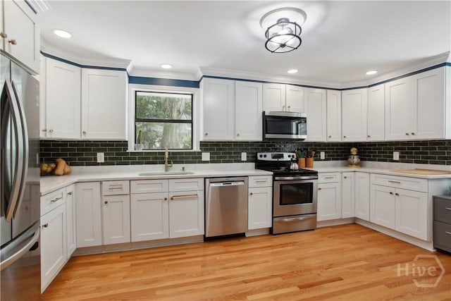 5527 Habersham St, Savannah, GA 31405 - kitchen featuring appliances with stainless steel finishes, light countertops, tasteful backsplash, light wood finished floors, and white cabinetry