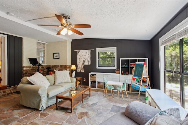 5527 Habersham St, Savannah, GA 31405 - living area with lofted ceiling, stone floors, ceiling fan, and a textured ceiling