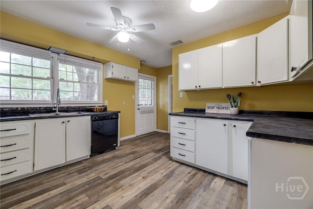 41 Barrington Cir, Savannah, GA 31419 - kitchen with dishwasher, dark countertops, light wood-style flooring, white cabinetry, and a ceiling fan