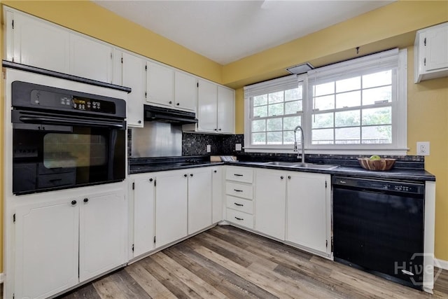 41 Barrington Cir, Savannah, GA 31419 - kitchen with black appliances, under cabinet range hood, dark countertops, white cabinets, and light wood-style flooring