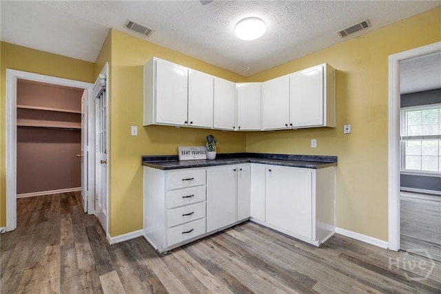 41 Barrington Cir, Savannah, GA 31419 - kitchen featuring light wood-style flooring, dark countertops, white cabinetry, and a textured ceiling