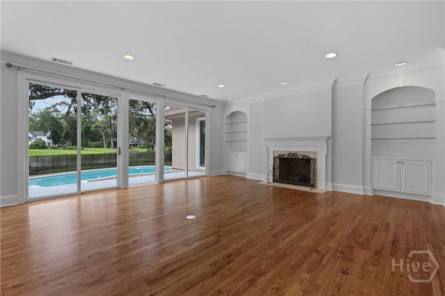 8 Boars Nest Ln, Savannah, GA 31411 - unfurnished living room with built in features, wood finished floors, recessed lighting, a fireplace, and crown molding