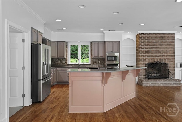 8 Boars Nest Ln, Savannah, GA 31411 - kitchen with stainless steel appliances, ornamental molding, a kitchen breakfast bar, dark wood-style floors, and decorative backsplash