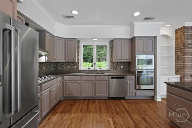 8 Boars Nest Ln, Savannah, GA 31411 - kitchen with appliances with stainless steel finishes, gray cabinets, dark wood-type flooring, ornamental molding, and tasteful backsplash