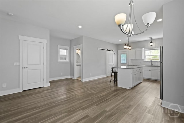 623 E Henry St, Savannah, GA 31401 - kitchen featuring a barn door, a chandelier, a center island, white cabinetry, and backsplash