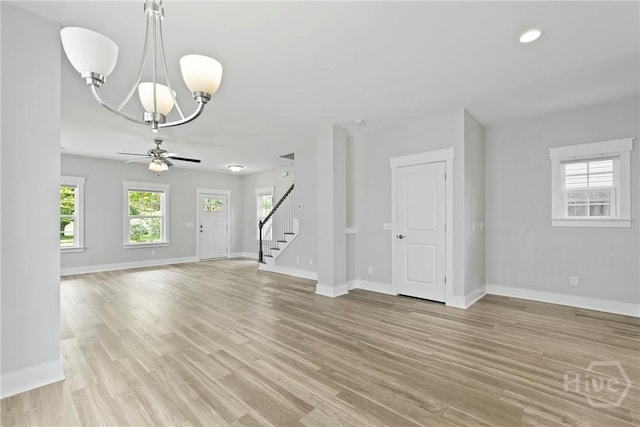 623 E Henry St, Savannah, GA 31401 - unfurnished living room with stairway, a chandelier, light wood-type flooring, a ceiling fan, and recessed lighting
