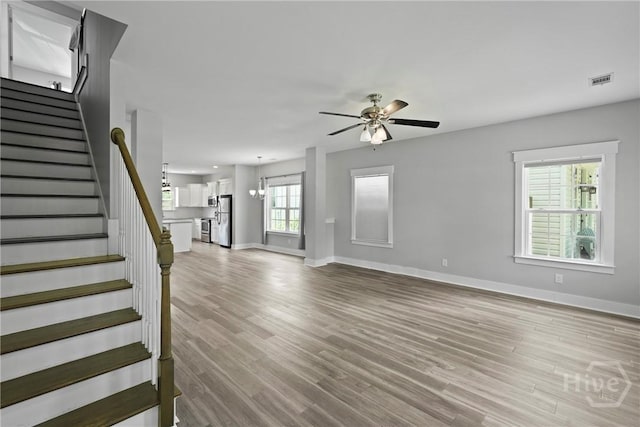 623 E Henry St, Savannah, GA 31401 - unfurnished living room with ceiling fan, stairs, and light wood finished floors