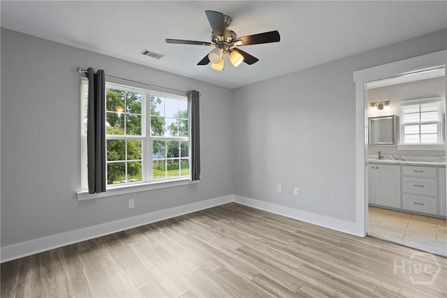 623 E Henry St, Savannah, GA 31401 - unfurnished bedroom featuring multiple windows, light wood-type flooring, and a ceiling fan