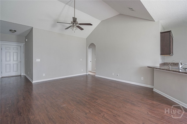 1506 Bayberry Dr, Hinesville, GA 31313 - unfurnished living room featuring ceiling fan, lofted ceiling, arched walkways, and dark wood-type flooring