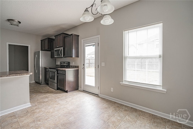 1506 Bayberry Dr, Hinesville, GA 31313 - kitchen with appliances with stainless steel finishes, a chandelier, dark brown cabinetry, light stone countertops, and a textured ceiling