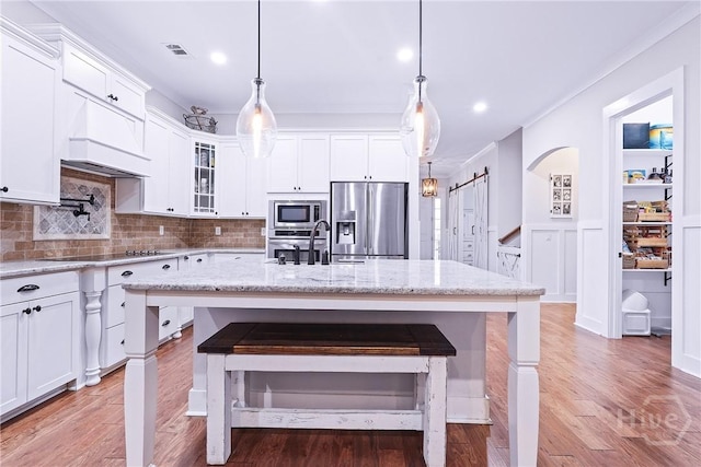 370 Blackjack Oak Dr W, Richmond Hill, GA 31324 - kitchen featuring stainless steel appliances, a breakfast bar, glass insert cabinets, backsplash, and white cabinets