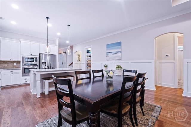 370 Blackjack Oak Dr W, Richmond Hill, GA 31324 - dining space with ornamental molding, wainscoting, wood finished floors, arched walkways, and recessed lighting