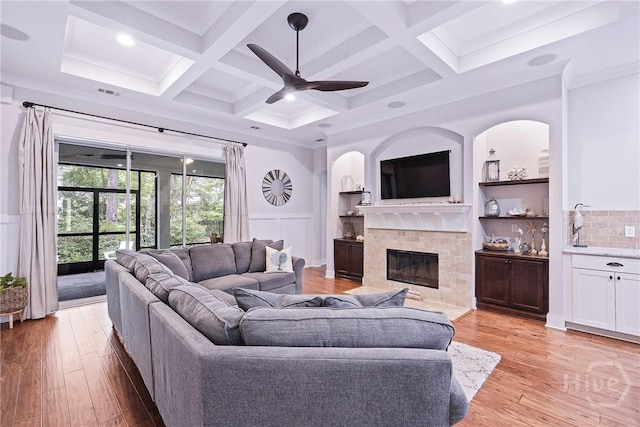 370 Blackjack Oak Dr W, Richmond Hill, GA 31324 - living room featuring a tiled fireplace, light wood finished floors, ceiling fan, coffered ceiling, and beam ceiling