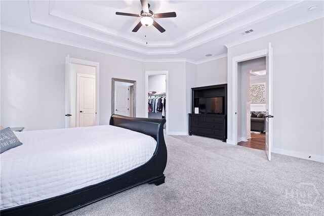 370 Blackjack Oak Dr W, Richmond Hill, GA 31324 - carpeted bedroom featuring a tray ceiling, ornamental molding, a walk in closet, a closet, and ceiling fan