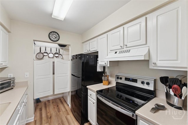 12300 Apache Ave Unit 1003, Savannah, GA 31419 - kitchen featuring ventilation hood, stainless steel electric stove, freestanding refrigerator, and white cabinetry
