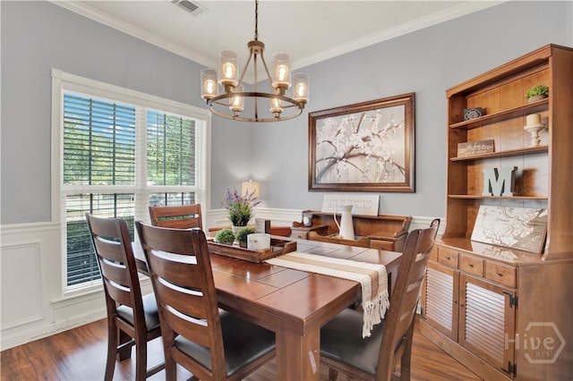 306 Walthour Dr, Rincon, GA 31326 - dining area featuring a chandelier, ornamental molding, wood finished floors, wainscoting, and a decorative wall