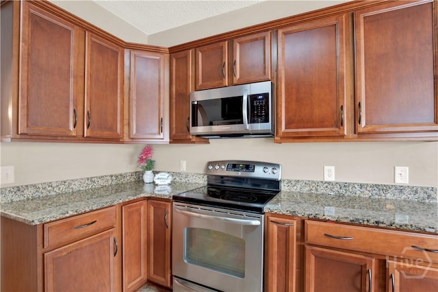 306 Walthour Dr, Rincon, GA 31326 - kitchen featuring appliances with stainless steel finishes, light stone counters, and brown cabinets