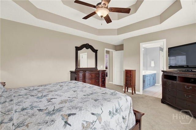 306 Walthour Dr, Rincon, GA 31326 - bedroom with light colored carpet, a tray ceiling, ensuite bath, and a ceiling fan