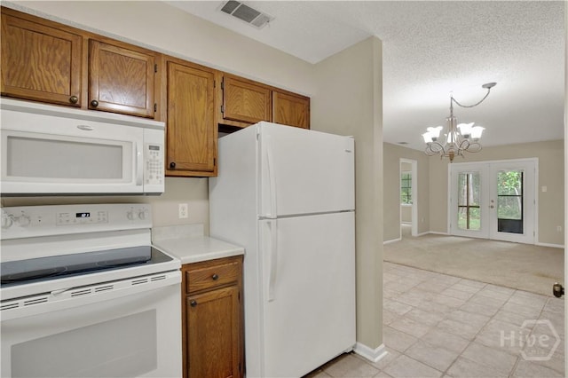 25 Colony Park Dr, Savannah, GA 31406 - kitchen featuring white appliances, a chandelier, brown cabinetry, light colored carpet, and a textured ceiling
