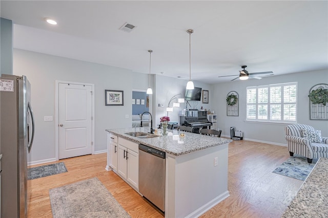 143 Arusha Ave, Savannah, GA 31419 - kitchen with stainless steel appliances, open floor plan, white cabinetry, light wood-style floors, and a ceiling fan