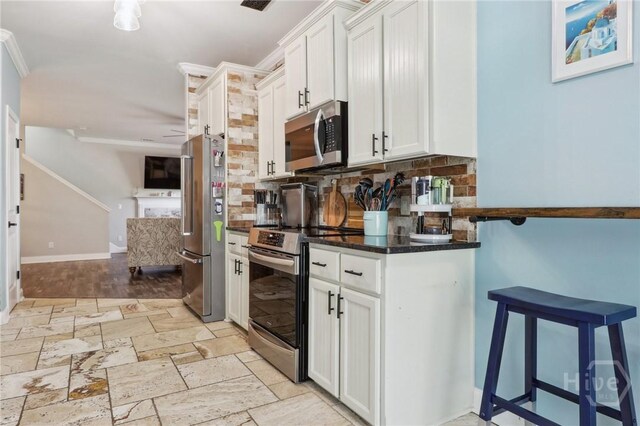 18 Sagefield Dr, Ellabell, GA 31308 - kitchen with stainless steel appliances, tasteful backsplash, stone tile flooring, and white cabinetry