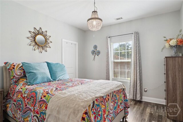 18 Sagefield Dr, Ellabell, GA 31308 - bedroom with wood finished floors and a chandelier