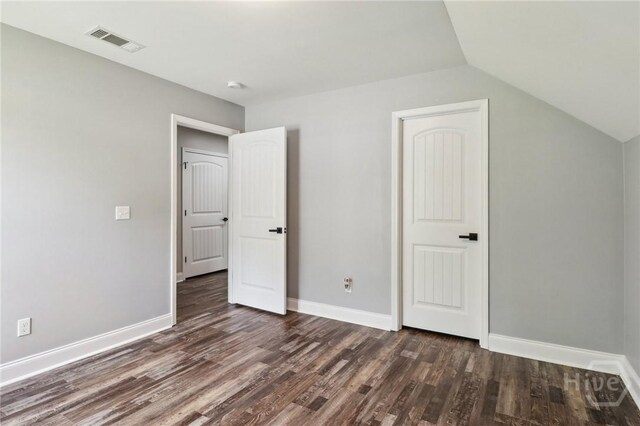 18 Sagefield Dr, Ellabell, GA 31308 - unfurnished bedroom with dark wood-type flooring and lofted ceiling