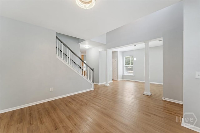 146 Royal Ln, Pooler, GA 31322 - unfurnished living room with wood finished floors, stairs, a chandelier, and decorative columns