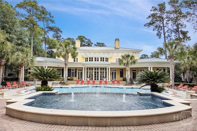 1212 Whitemarsh Way, Savannah, GA 31410 - rear view of property featuring a chimney, a standing seam roof, french doors, a patio area, and a community pool