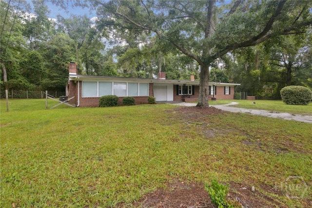 406 E 3rd St, Springfield, GA 31329 - ranch-style home featuring a chimney, brick siding, concrete driveway, a garage, and view of scattered trees
