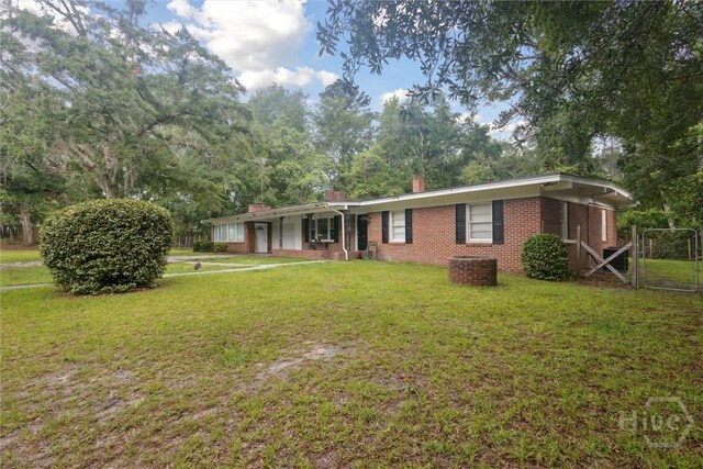 406 E 3rd St, Springfield, GA 31329 - ranch-style house with brick siding, a front lawn, a chimney, and a porch