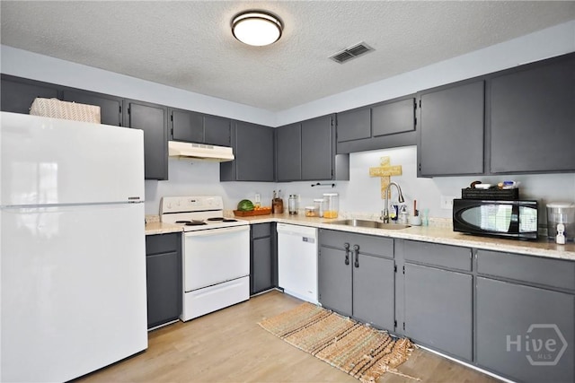 316 Clairemore Cir, Hinesville, GA 31313 - kitchen featuring white appliances, under cabinet range hood, a textured ceiling, light wood finished floors, and light countertops