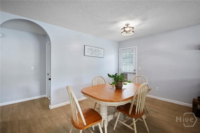 316 Clairemore Cir, Hinesville, GA 31313 - dining space featuring arched walkways, wood finished floors, and a textured ceiling
