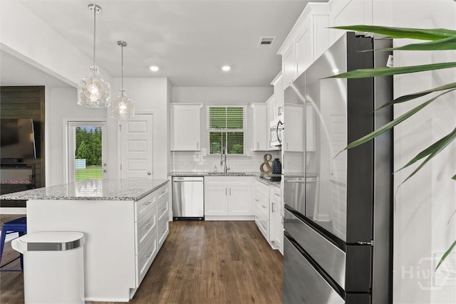 104 Finch Ln, Guyton, GA 31312 - kitchen with stainless steel appliances, dark wood-type flooring, tasteful backsplash, a kitchen island, and healthy amount of natural light