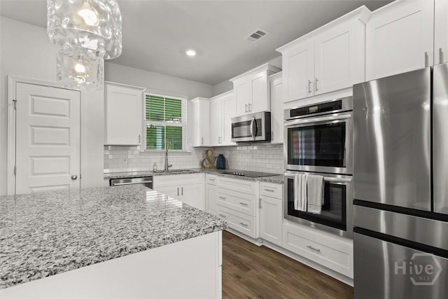 104 Finch Ln, Guyton, GA 31312 - kitchen with stainless steel appliances, white cabinetry, tasteful backsplash, light stone countertops, and recessed lighting