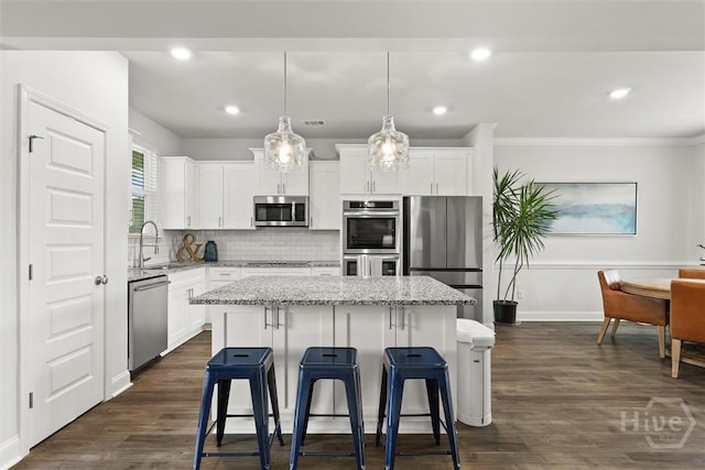 104 Finch Ln, Guyton, GA 31312 - kitchen featuring stainless steel appliances, a center island, a kitchen breakfast bar, white cabinetry, and recessed lighting