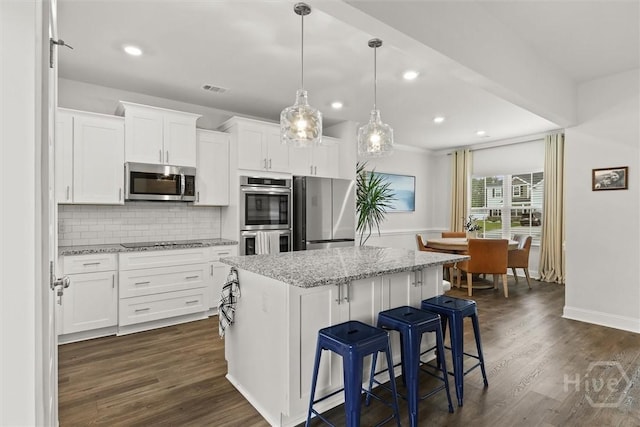 104 Finch Ln, Guyton, GA 31312 - kitchen featuring stainless steel appliances, a kitchen island, white cabinets, light stone counters, and dark wood-type flooring