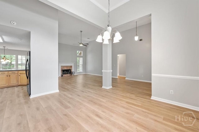 65 Golden Gate Dr, Pooler, GA 31322 - unfurnished living room with a chandelier, a ceiling fan, a fireplace, light wood finished floors, and a high ceiling