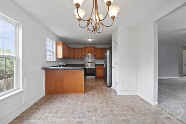 15 Springwater Dr, Port Wentworth, GA 31407 - kitchen featuring appliances with stainless steel finishes, under cabinet range hood, a chandelier, a peninsula, and dark countertops