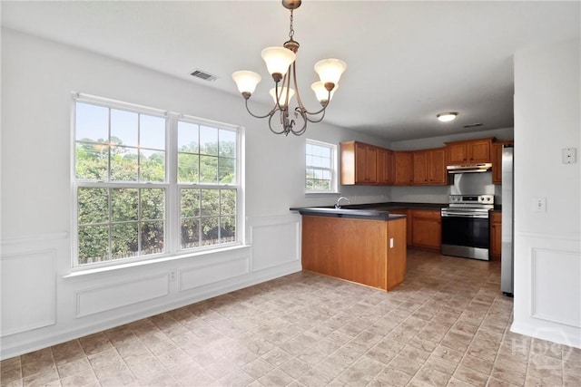 15 Springwater Dr, Port Wentworth, GA 31407 - kitchen with stainless steel appliances, under cabinet range hood, a decorative wall, a chandelier, and a peninsula