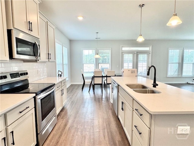 135 Melody Dr, Pooler, GA 31322 - kitchen featuring stainless steel appliances, light wood-style flooring, backsplash, light countertops, and hanging light fixtures