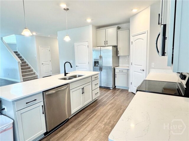 135 Melody Dr, Pooler, GA 31322 - kitchen with stainless steel appliances, light wood-style floors, hanging light fixtures, a center island with sink, and recessed lighting