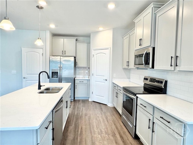 135 Melody Dr, Pooler, GA 31322 - kitchen with stainless steel appliances, wood finished floors, backsplash, hanging light fixtures, and a center island with sink