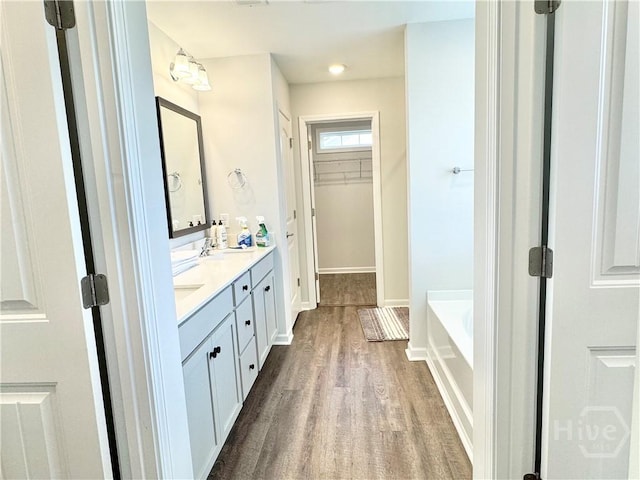 135 Melody Dr, Pooler, GA 31322 - bathroom featuring double vanity, wood finished floors, a bath, and a walk in closet